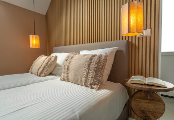 Modernes Schlafzimmer in der Wellness Lodge im Holiday Park De IJsvogel mit Holzwänden und gemütlicher Beleuchtung.