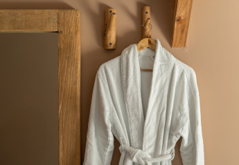 A white bathrobe on a wooden hook at the Wellness Lodge in Holiday Park De IJsvogel, Netherlands.