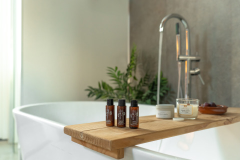 Vasca rilassante in Wellness Lodge con prodotti spa e candela al Holiday Park De IJsvogel nei Paesi Bassi.