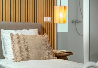 Modern bedroom at the Wellness Lodge in Holiday Park De IJsvogel, Netherlands, with cozy lighting and bath.