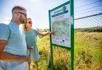 Two people read a map at Knooppunt 67 in Zuid-Limburg near Berg Lodge - Sauna at Resort Mooi Bemelen.