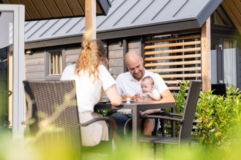 Famille prenant le petit-déjeuner dehors à la Berg Lodge - Sauna, Resort Mooi Bemelen, Pays-Bas, été.