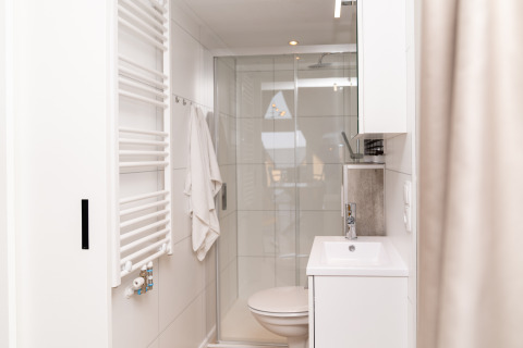 Salle de bain moderne avec douche, serviette et lavabo à Berg Lodge - Sauna, Resort Mooi Bemelen, Pays-Bas.