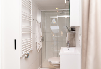 Salle de bain moderne avec douche, serviette et lavabo à Berg Lodge - Sauna, Resort Mooi Bemelen, Pays-Bas.