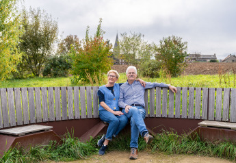 Elderly couple sitting together on a wooden bench at Berg Lodge - Sauna, Resort Mooi Bemelen, Netherlands.