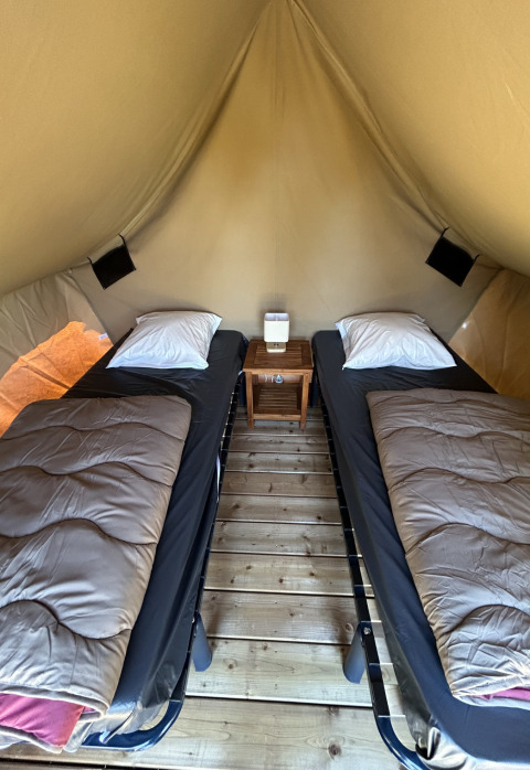 Indretning af safari teltet SLOW LIFE VERBLIJF med to enkeltsenge på Camping Seasonova Les Marguerites.