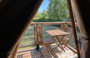 Vista desde una tienda safari en SLOW LIFE VERBLIJF, Camping Seasonova Les Marguerites, terraza de madera con mesa.