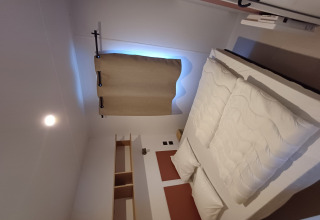 Camera da letto in un cottage al Camping Floreal La Roche-en-Ardenne, Belgio, con letto matrimoniale.