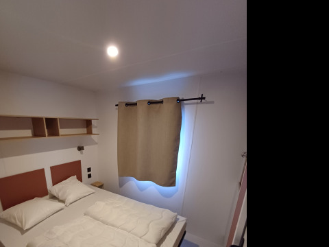 Camera da letto in un cottage al Camping Floreal La Roche-en-Ardenne, Belgio, con letto matrimoniale.