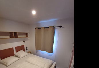 Camera da letto in un cottage al Camping Floreal La Roche-en-Ardenne, Belgio, con letto matrimoniale.
