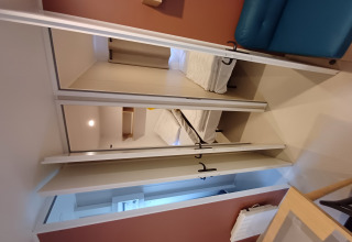 Interno di un cottage al Camping Floreal La Roche-en-Ardenne con letto, divano e arredo moderno.