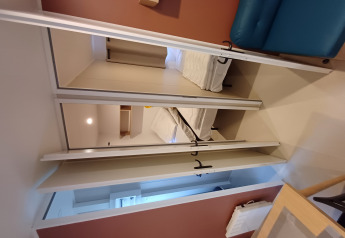 Interior de una cabaña en Camping Floreal La Roche-en-Ardenne con cama, sofá y decoración moderna.