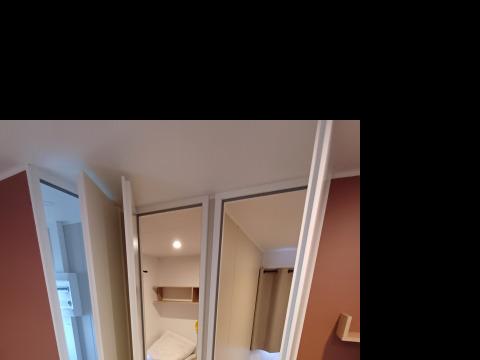 Interieur van een cottage op Camping Floreal La Roche-en-Ardenne met bed, bank en modern interieur.