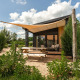 Tiny house Sand Lodge met terras en schaduwdoek bij Holiday Park De IJsvogel, omringd door natuur.