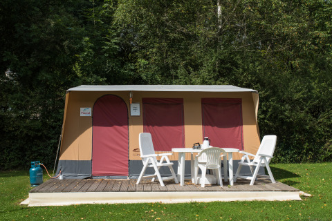 Tenda safari Comforttent al Camping Floreal La Roche-en-Ardenne in Belgio con mobili da giardino bianchi.