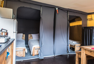 Interno della tenda safari Comforttent al Camping Floreal La Roche-en-Ardenne con letti e cucina.