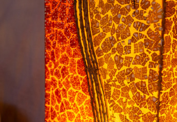 Nærbillede af en farverig, mosaikdesignet lampe med varme røde og gule nuancer i et fransk yurt.