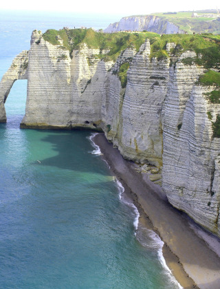 Coastal landscape near Yport in Normandy, France, with white chalk cliffs and the blue sea below.