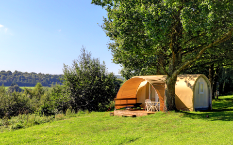 Coco Sweet safaritent op Camping La Colline in België, beschut onder bomen en in het groene landschap.