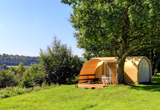 Coco Sweet safaritent op Camping La Colline in België, beschut onder bomen en in het groene landschap.