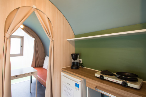 Innenansicht eines Coco Sweet Safari-Zeltes auf Camping La Colline in Belgien mit Küchenzeile und Sitzbereich.