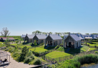 Moderne Ferienhäuser im Villa Oesterdam im Oesterdam Resort, Niederlande, gelegen in einer grünen Landschaft.