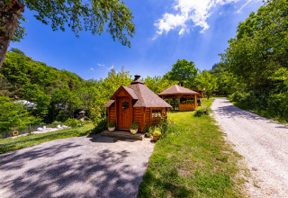 Idyllische Ansicht vom Camping Des Randonneurs in Occitanie, Frankreich, mit Holzhütten in grüner Natur.