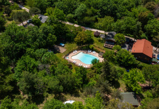 Vista aerea di Camping Des Randonneurs in Occitania, Francia, con piscina immersa tra alberi verdi.