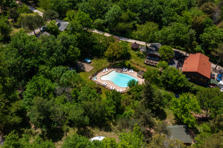 Vista aerea di Camping Des Randonneurs in Occitania, Francia, con piscina immersa tra alberi verdi.