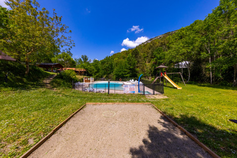 Vista esterna di Camping Des Randonneurs in Occitania, Francia, con piscina, area giochi e campo da pétanque.