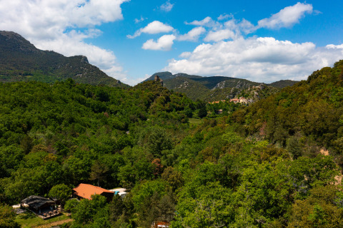 Panoramisch zicht op Camping Des Randonneurs in Occitanië, Frankrijk, met heuvels en groene bossen.
