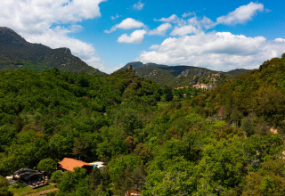 Panoramisch zicht op Camping Des Randonneurs in Occitanië, Frankrijk, met heuvels en groene bossen.