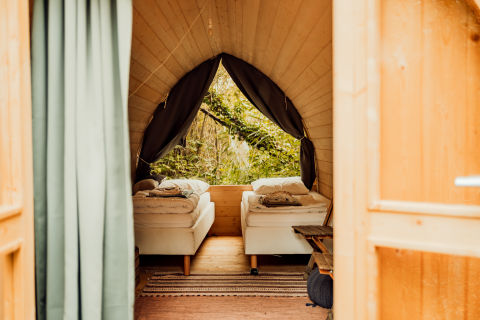 Vista interna di un Premium - Duo Panorama Pod con due letti singoli e ampie finestre sulla natura.