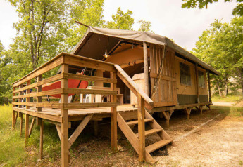 Safari Lodge tent bij Camping Centro Vacanze San Marino, met houten terras en omgeven door groen bos.