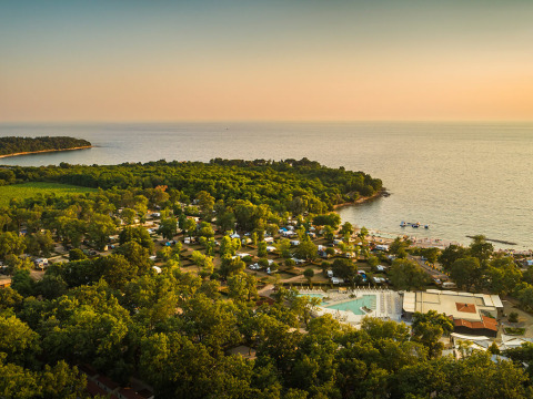 Luftfoto af Aminess Planet Camping Maravea Resort i Istrien, Kroatien, omgivet af skov og kystlinje.