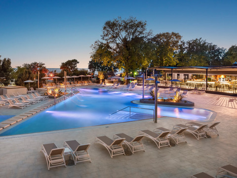 Aftenbillede af swimmingpool og liggestole på Aminess Planet Camping Maravea Resort i Istrien, Kroatien.