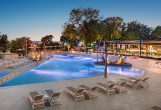Vista nocturna de la piscina y tumbonas en Aminess Planet Camping Maravea Resort en Istria, Croacia.