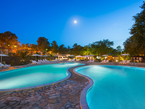 Piscina illuminata all'Aminess Planet Camping Maravea Resort in Istria, Croazia, durante una serata limpida.