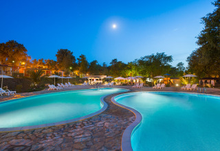 Piscine éclairée à Aminess Planet Camping Maravea Resort en Istrie, Croatie, sous un ciel du soir clair.
