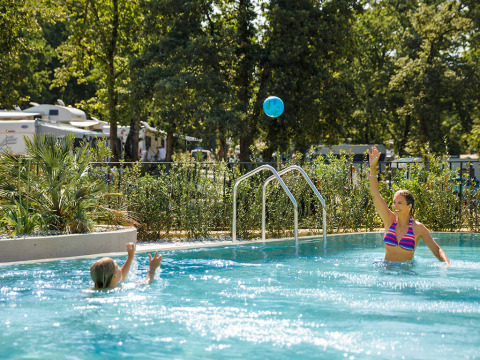 Moeder en kind spelen met een bal in het zwembad van Aminess Planet Camping Maravea Resort in Istrië, Kroatië.