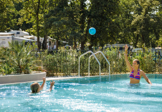 Moeder en kind spelen met een bal in het zwembad van Aminess Planet Camping Maravea Resort in Istrië, Kroatië.