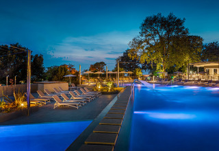 Piscina iluminada en Aminess Planet Camping Maravea Resort, Istria, Croacia, con tumbonas al atardecer.