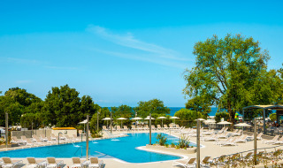 Zona de piscina con tumbonas en Aminess Planet Camping Maravea Resort, un parque vacacional en Istria, Croacia.