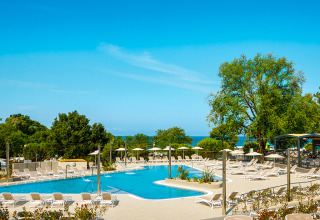 Zona de piscina con tumbonas en Aminess Planet Camping Maravea Resort, un parque vacacional en Istria, Croacia.