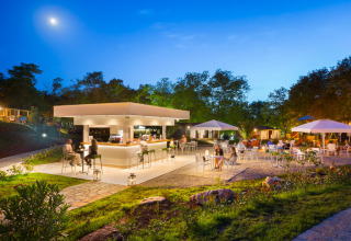 Bar extérieur lumineux au Maravea Premium Holiday Home, Aminess Planet Camping Maravea Resort, Croatie, au crépuscule.