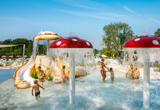 Kinder spielen im Wasserpark mit Rutschen und Pilzfontänen im Aminess Planet Camping Maravea Resort in Istrien.