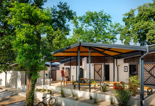 Paar entspannt sich vor modernen Bungalows im Grünen im Aminess Planet Camping Maravea Resort, Istrien, Kroatien.