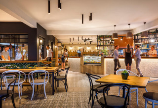 Moderno restaurante y zona de bar en Aminess Planet Camping Maravea Resort en Istria, Croacia, con huéspedes.