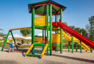 Kinderen spelen op een kleurrijke speeltuin met glijbaan en schommels bij Aminess Planet Camping Maravea Resort in Istrië.