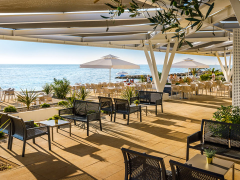 Terraza frente al mar con mesas, sillas y sombrillas en Aminess Planet Camping Maravea Resort en Istria, Croacia.